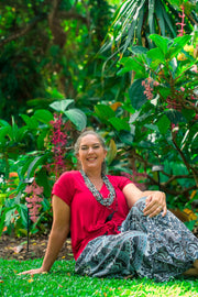 Freya Pants - Grey boho pants for women with mandala print, worn outdoors with red top. Lightweight rayon fabric ideal for casual summer wear.