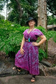 Mayan Midi Dress Aztec Magenta in boho style with geometric tribal print, flexible fit for sizes 8-16, modeled outdoors in lush greenery.