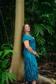 Mayan Midi Dress - Aztec Teal with bold tribal patterns, styled in a lush tropical setting. Features a relaxed, free-size fit for sizes 8 to 16.